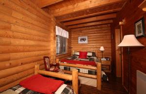 a bedroom with two beds in a log cabin at Tuckamore Lodge in Main Brook