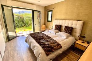 une chambre avec un grand lit et une grande fenêtre dans l'établissement VILLA CORSA**** PISCINE VUE MER PANORAMIQUE, à Santa-Reparata-di-Balagna 39 autres photos