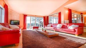 a living room with red couches and a table at Villa Duda - A Unique Memory in Vodnjan