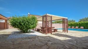 a gazebo with a bench next to a pool at Villa Duda - A Unique Memory in Vodnjan