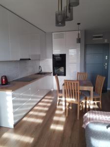a kitchen and dining room with a table and chairs at Apartament na Strzeleckiej in Płock