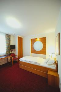 um quarto de hotel com uma cama e um espelho em Hotel am Mühlbach em Forbach