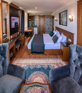 a hotel room with a bed and two chairs at Duru Sultanahmet Apart & Suites in Istanbul