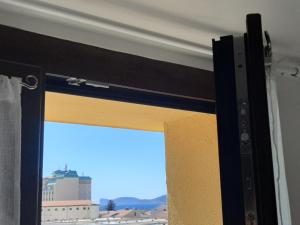 una porta scorrevole in vetro con vista su un edificio di Cuscino e Cappuccino B&B ad Alghero