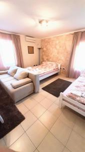 een woonkamer met een bank en een bed bij apartman Marija 2 in Srbobran