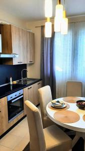 een keuken en eetkamer met een tafel en stoelen bij apartman Marija 2 in Srbobran