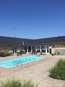 a swimming pool in front of a building at Skuldelev kro in Skibby