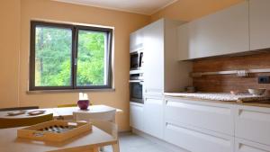 una cocina con armarios blancos y una ventana en In Collina B&B en Trento