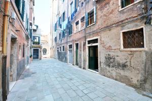 een leeg steegje in een oude stad met gebouwen bij Casanova Flat in Venetië