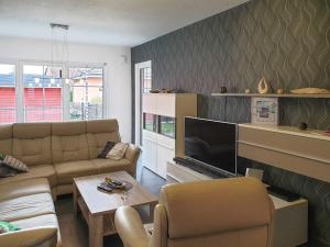 uma sala de estar com um sofá e uma televisão em Karlshagen Ferienhaus Sandy em Ostseebad Karlshagen
