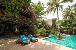Cayena Beach Villa في Guachaca: مسبح ذو كرسيين ازرق بجانب منتجع