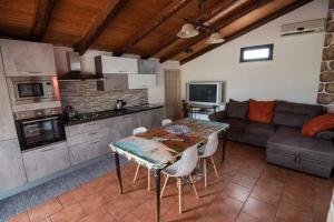 una cucina e un soggiorno con tavolo e divano di Villa Sole a Torrenova