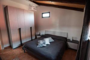 una camera da letto con un letto nero con due cuscini sopra di Villa Sole a Torrenova