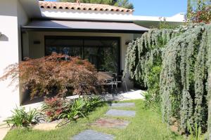 um jardim com uma cerca e uma mesa ao fundo em Villa Chaptalia em Bandol