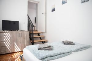 a white room with a bed and a tv at APARTMAN TEA 2 in Belgrade