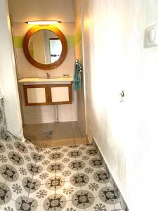 a bathroom with a sink and a tile floor at Ruoms Petite Maison 3* centre-village in Ruoms