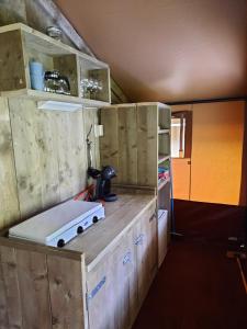 a kitchen with wooden cabinets and a counter top at Safaritent Kvikkjokk Vledder, locatie Kraanvogels 3 in Vledder