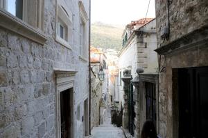 un callejón con una persona caminando por una calle en Old Town centar, cozy and quiet modern apartment en Dubrovnik