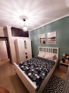 a bedroom with a bed and a green wall at Sweet Apartment in Thessaloniki