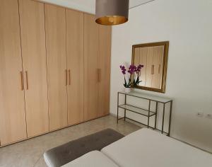 een woonkamer met een bank en een spiegel bij Rodos Beach Apartment 33 in Rhodos-stad