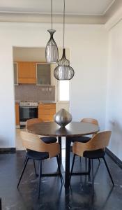 een eettafel met 2 stoelen en 2 hanglampen bij Rodos Beach Apartment 33 in Rhodos-stad +10 foto's