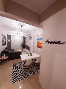 a living room with a home sign on a wall at Sweet Apartment in Thessaloniki +27 photos