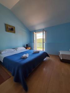 a blue bedroom with a bed with two towels on it at Apartments Dabelić in Polače