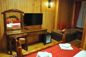 a room with a tv and a bed and a mirror at Inan Kardesler Hotel in Uzungöl