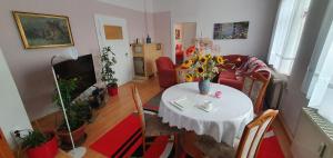 Ferienwohnung Moritzburg mit Pool في موريتزبورغ: غرفة معيشة مع طاولة مع إناء من الزهور عليها