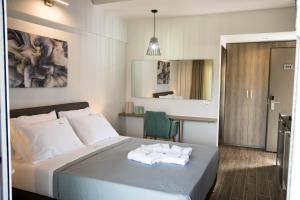 een slaapkamer met een bed met handdoeken erop bij Aelia Luxury Apartments in Nikiti