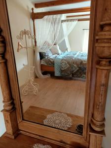 a mirror reflection of a bedroom with a bed at Bij de Friesche Poort in Bourtange