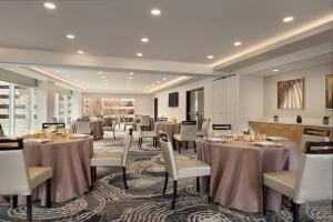 une salle à manger avec des tables et des chaises dans une pièce dans l'établissement Hyatt House Atlanta Perimeter Center, à Atlanta