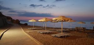 een groep parasols en stoelen op een strand bij Rodos Beach Apartment 33 in Rhodos-stad