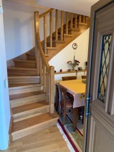 a dining room with a wooden staircase and a table at Ξύλο & Παράδοση in Pávliani