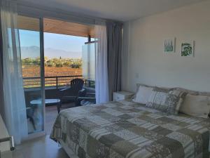 1 dormitorio con 1 cama y balcón con vistas. en Increíble departamento en Luján de Cuyo, imponente vista a la montaña en Luján de Cuyo