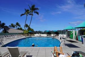 una piscina con gente en sillas alrededor en New Aloha Ilikai 1free Parking, en Honolulu