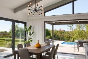 a dining room with a table and chairs and a pool at Villa Artemis in Sveti Petar u Šumi