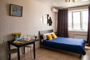 ノヴォロシースクにあるАпартаменты Мильфей 19-3のベッドルーム1室(ベッド1台、テーブル、デスク付)