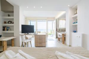 a bedroom with a bed and a desk with a television at Junior suite by the beach Stalida in Stalida