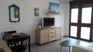 a living room with a tv on a wooden cabinet at Malagueta & Port in Málaga