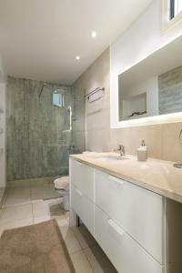 a white bathroom with a shower and a sink at Junior suite by the beach Stalida in Stalida