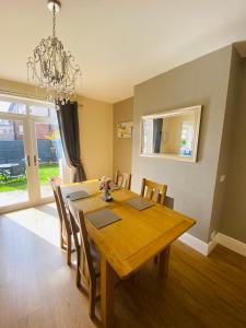 a dining room table with chairs and a chandelier at Acacia Breezes - Delightful Scarborough Semi in Scarborough