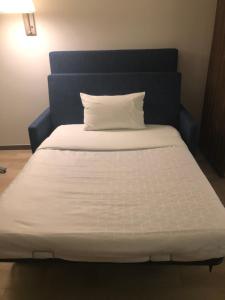 a white bed with a blue headboard and a white pillow at Holiday Inn Express & Suites - Playa del Carmen, an IHG Hotel in Playa del Carmen