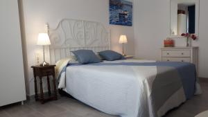 a bedroom with a large white bed with blue pillows at Malagueta & Port in Málaga