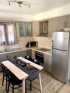 a kitchen with a table and a stainless steel refrigerator at Leo's city apartment in Lefkada