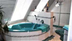 a bathroom with a bath tub with a sink at Galerie Ueber den Gaerten in Herbolzheim +37 photos