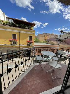 einen Balkon mit Stühlen und ein Gebäude in der Unterkunft NG Guest House il Gallura in Olbia
