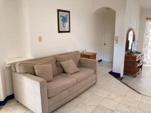 a living room with a couch and a television at Aca Suites Ixtapa in Ixtapa