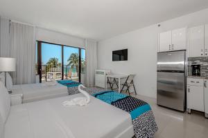 a bedroom with two beds and a kitchen with a balcony at Beach Front Studio Miami Beach in Miami Beach +235 photos