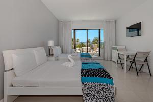 a bedroom with a white bed and a table and chairs at Beach Front Studio Miami Beach in Miami Beach